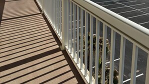 A covered walkway with a view of the ocean and a parking area. - Oceanfront 1-bedroom condo with spectacular sunrises Pool Gym Jacuzzi Sauna 🏖️ (Daytona Beach)