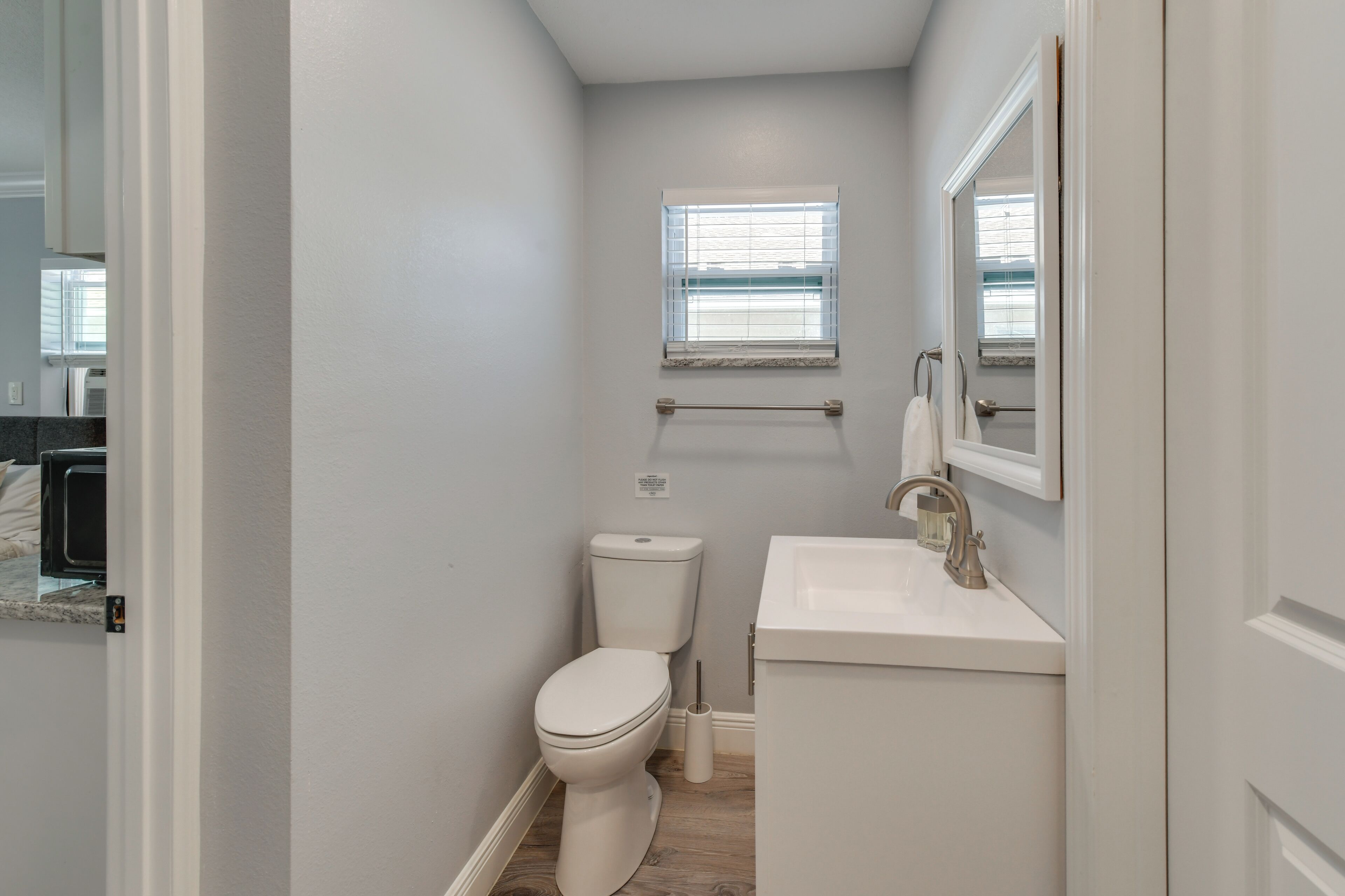 A compact bathroom with a toilet, sink, and window.
