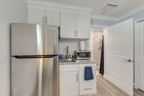 A compact kitchen with white cabinets, a stainless steel refrigerator, a microwave, and a sink. - 2 Mi to Bayfront Park: Charming Couple's Getaway (Sarasota)