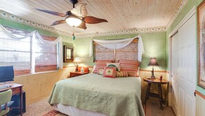 A room with a bed, a desk, a chair, a ceiling fan, and a window with curtains. - Lake Harris Retreat: 2 Docks & Kayaks! (Leesburg)