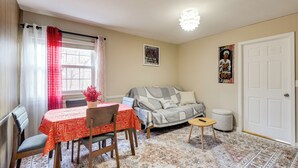 A cozy living room with a dining table, chairs, a sofa, and a small ottoman. - Convenient + Cozy! Apartment in DC Suburbs! (Silver Spring)