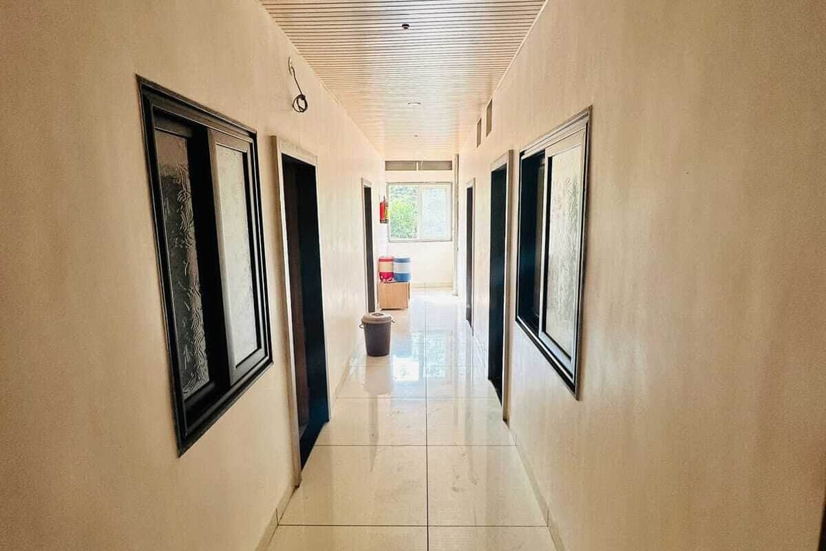A long, narrow hallway with tiled floors and a slatted ceiling.