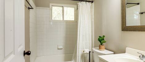 A bathroom with a bathtub, toilet, and sink.