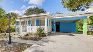A two-story house with a blue and white exterior, a covered porch, and a front yard with plants and a street lamp. - Walk to Shops & Dining: Downtown Stuart Home! (Stuart)