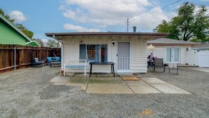 A small, single-story house with a porch, a table, and a bench. - 5 Mi to Dtwn Riverside & Hospital! Remote-work Hub (Riverside)