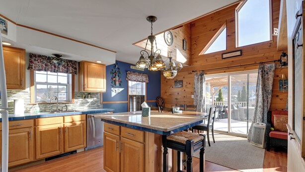 Una cocina amplia con armarios de madera, una isla grande y vistas al exterior.