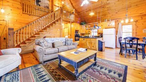 A wooden cabin interior with a staircase, living room, kitchen, and dining area. - Creek On-site! Cabin 7 Mi to Cataloochee Ski Area (Maggie Valley)