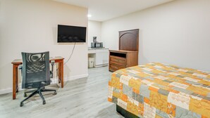 Une chambre d’hôtel équipée d’un lit, d’un bureau, d’une chaise, d’une télévision et d’une armoire.