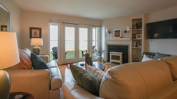 A living room with a sofa, a coffee table, a fireplace, and a television. - Stunning Views & Beach Access: Plattsburgh Getaway (Plattsburgh)