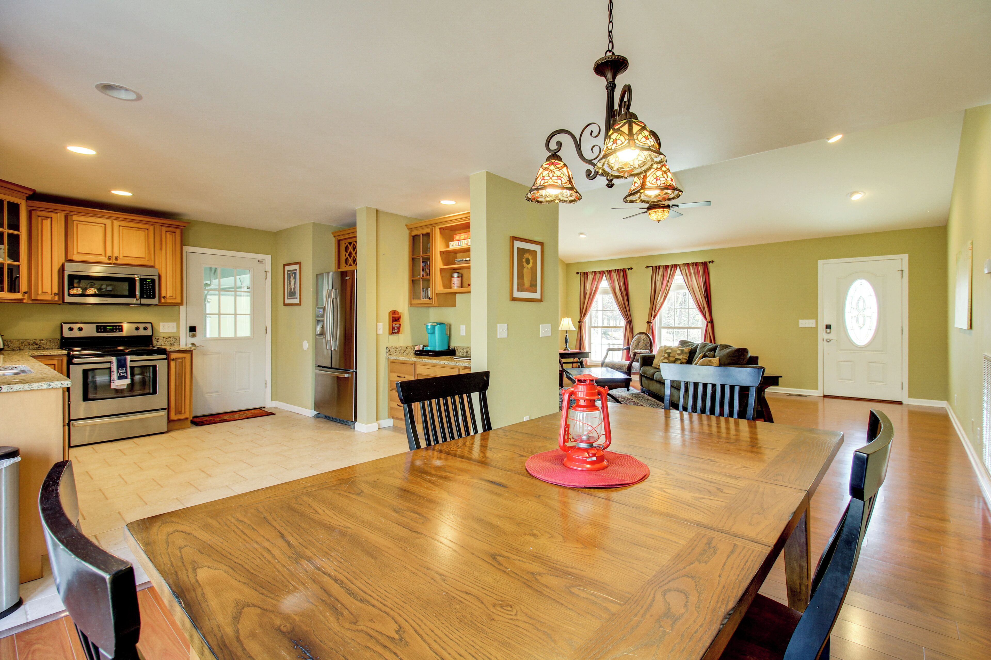 A spacious kitchen with wooden cabinets, a dining table, and a red lantern.