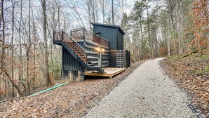 A cabin with a wooden deck and stairs, surrounded by a forest. - Secluded Red River Gorge Cabin w/ Rooftop Deck! (Campton)