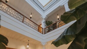 A spacious, multi-level interior with a balcony, a sofa, and a dining area. - Riad Babel (Marrakech)