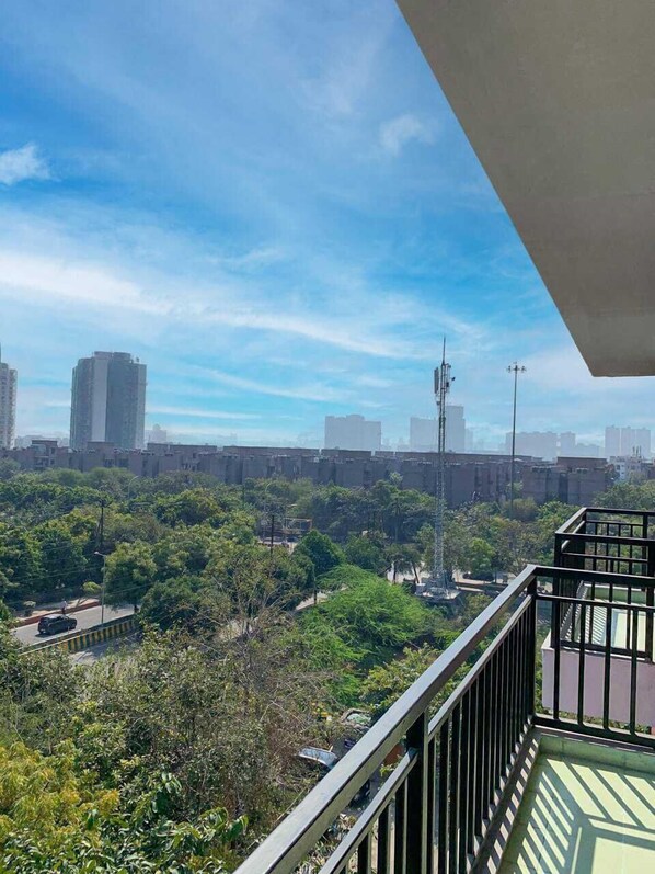 Een balkon met uitzicht op een stadsgezicht, inclusief wolkenkrabbers en een heldere lucht.