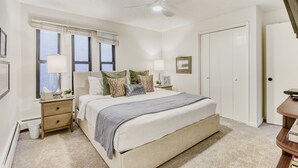 A bedroom with a bed, nightstands, a ceiling fan, a window with blinds, and a door. - Freshly Updated Condo, Across The Street From The Resort Edel O 2 Bedroom Apts (Park City)