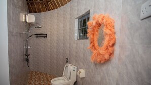 Un baño con inodoro, ducha y ventana.