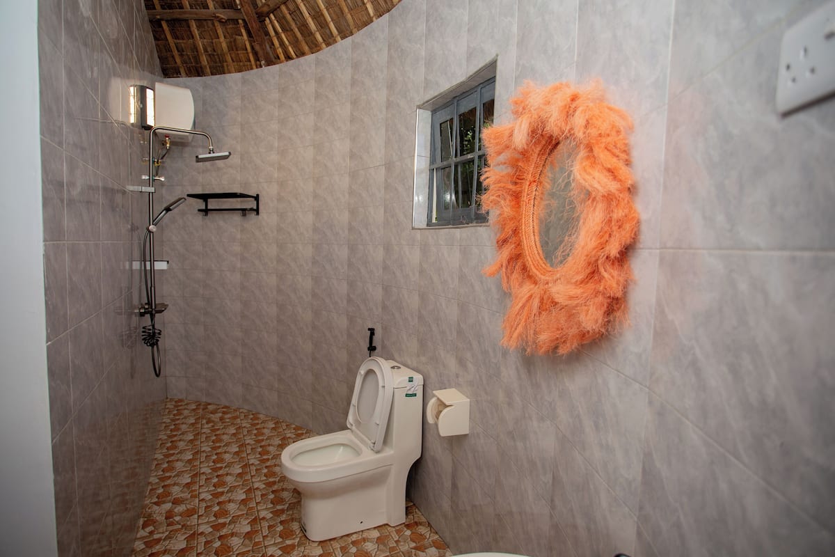 Ein Badezimmer mit Toilette, Dusche und einem Fenster.
