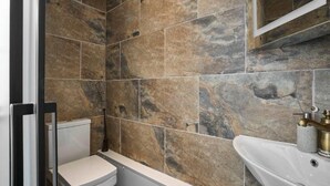 Un baño con inodoro, bañera y lavabo.