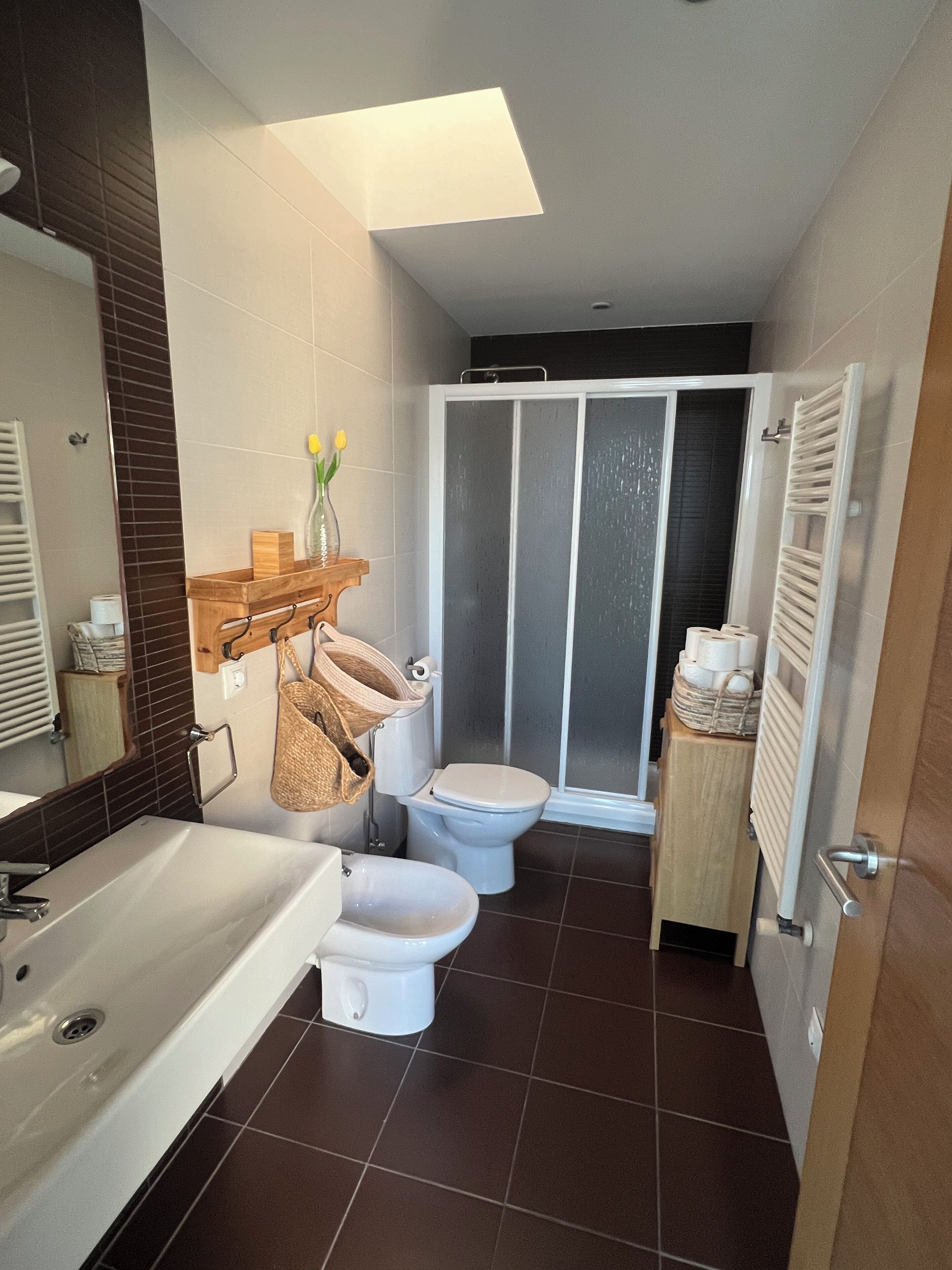 A modern bathroom with a bathtub, toilet, and shower.