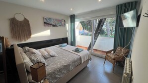 A bedroom with a bed, bedside table, and a view of the outside. - Vacation home for families in Cala Ferrera with private pool in the garden near the beach (Cala Ferrera)