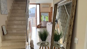 A spacious hallway with a staircase leading to a living area, a large mirror, and a potted plant. - Vacation home for families in Cala Ferrera with private pool in the garden near the beach (Cala Ferrera)