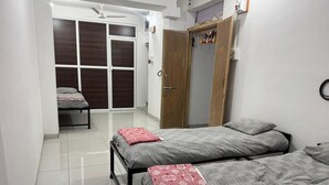 Un dormitorio con dos camas, un armario y un guardarropa.
