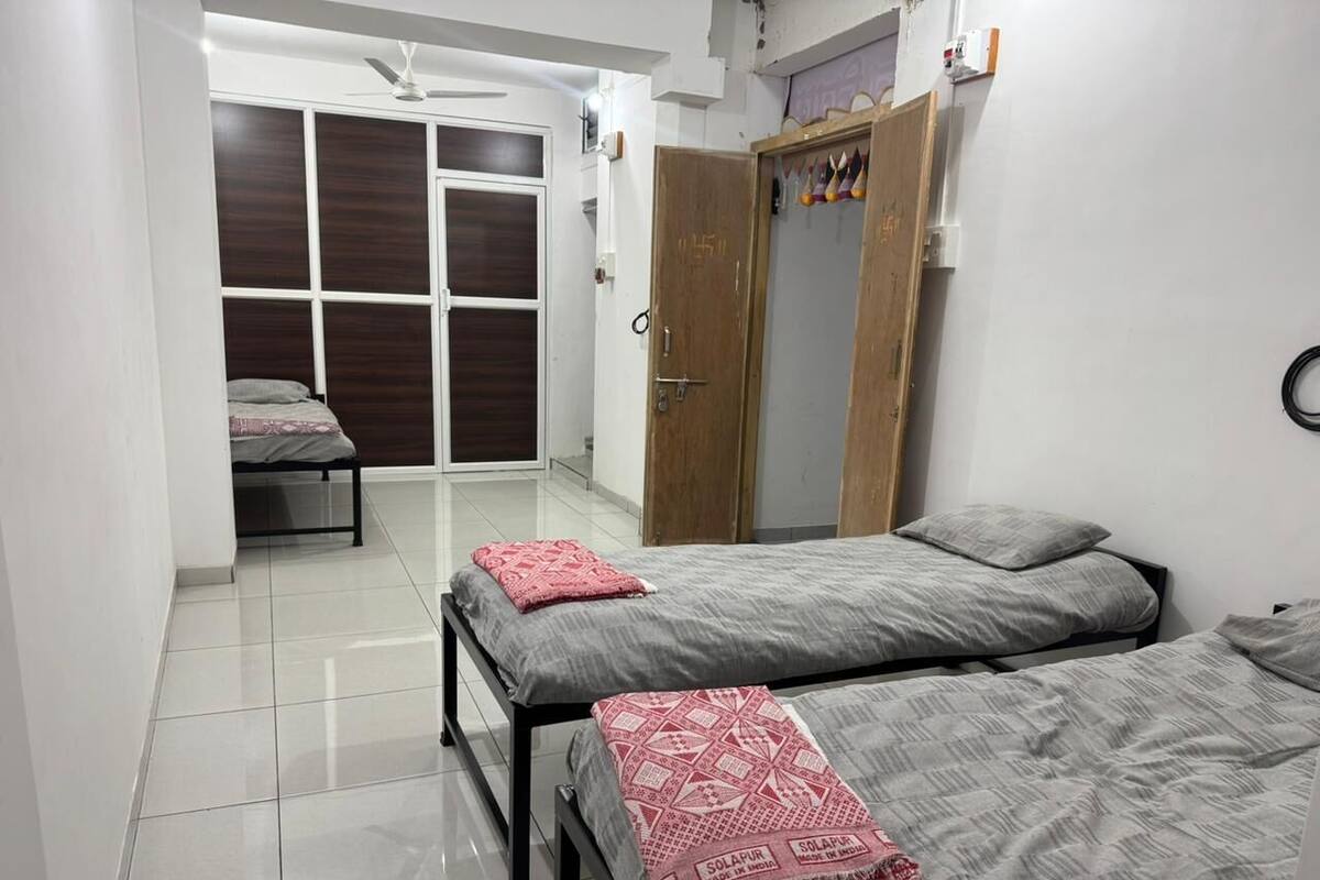 Une chambre avec deux lits, une armoire et un placard.