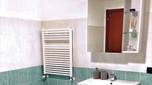 Une salle de bain avec une baignoire, un lavabo, un miroir et des toilettes.