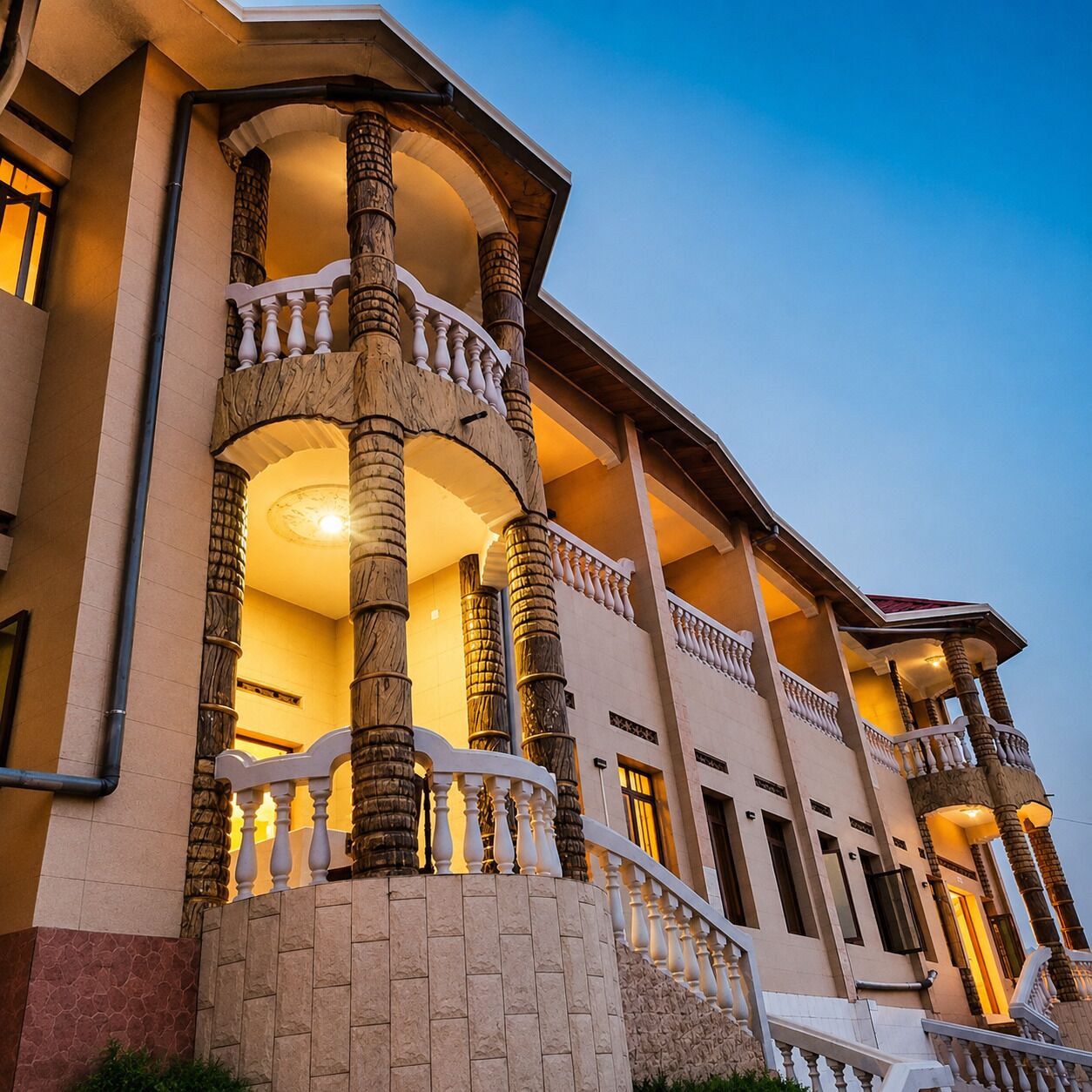 A multi-story building with a grand entrance featuring a balustrade and columns.