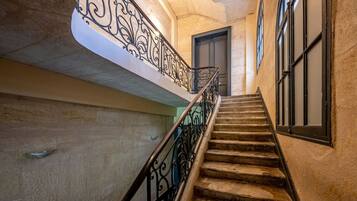 A staircase with ornate metal railings leading to a door.