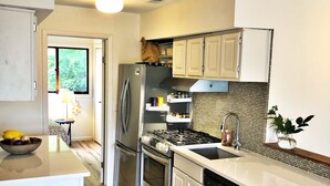 Eine moderne Küche mit Edelstahlgeräten, weißen Schränken und Holzboden.