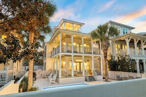 A two-story beachfront house with a balcony, a pool, and a white fence. - Steps from private beach access, this upscale dream home features a private pool (Seacrest Beach)