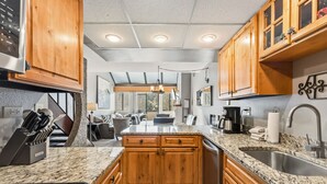 A modern kitchen with wooden cabinets, granite countertops, and stainless steel appliances.