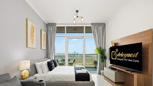 Ein modernes Hotelzimmer mit einem großen Bett, einem Fernseher und Blick auf die Stadtlandschaft.