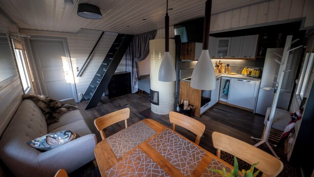 A modern interior with a sofa, dining table, and kitchen area.