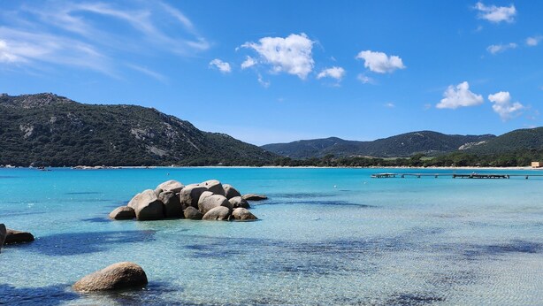 A coastal landscape with clear turquoise waters, rocky formations, and distant mountains under a blue sky. - CORSICA: LOUNICELI Villa with air conditioning, a pool, beaches, shops, and mountains (Zonza)
