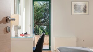 A bedroom with a bed, a desk with a chair, a window, and a door. - Private Oasis 5 minutes from the Diocletians Palace (Split)