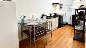 Une cuisine moderne avec un coin repas, des murs blancs et un plancher en bois.