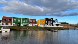 A row of colorful buildings by a calm body of water with a cloudy sky. - 4 Star Holiday Home in Ebeltoft (Ebeltoft)