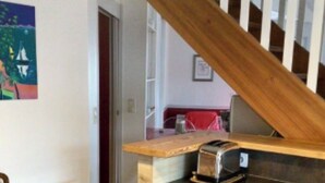 Een keuken met houten kastjes, een houten aanrecht en een broodrooster.
