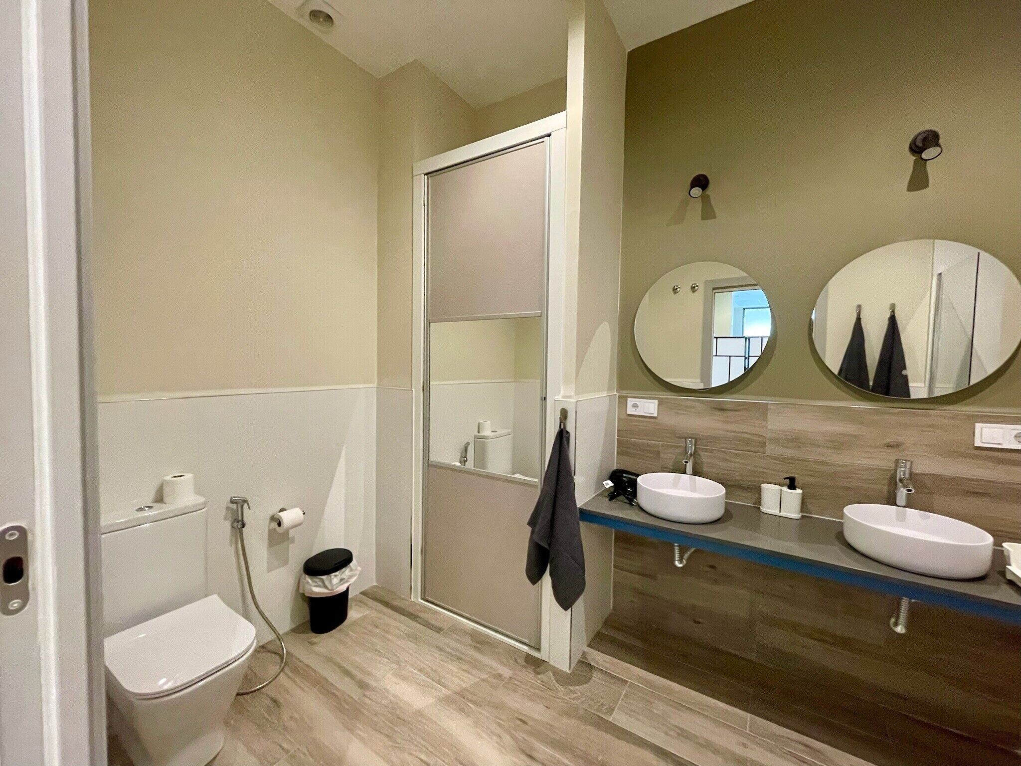 Et moderne badeværelse med toilet, to håndvaske og et spejl.