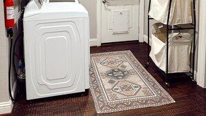 A laundry room with a washing machine, a fire extinguisher, a rug, and a drying rack. - 3-bedroom house in peaceful McKinney with cool AC for relaxing stays (McKinney)