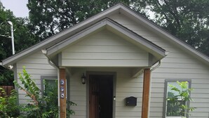 A single-story house with a front porch, a mailbox, and a small garden. - 3-bedroom house in peaceful McKinney with cool AC for relaxing stays (McKinney)