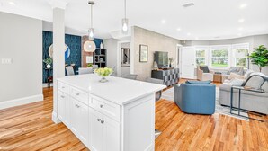A modern kitchen with white cabinetry, a central island, and pendant lighting. - Charming Renovated Home, Cozy for All! Pet friendly! (New Windsor)