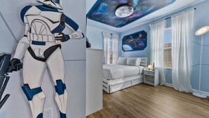 Una stanza con un letto, un affresco al soffitto e una statuetta di Star Wars.