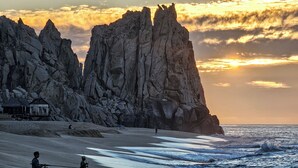 Paisatge costaner amb penya-segades rocoses i una platja.