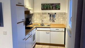 A modern kitchen with white cabinets, a wooden countertop, and a tiled backsplash. - Cozy apartment for 2 pers with all amenities, 50 meters from the lake (Bilice)