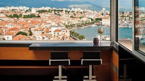 Eine moderne Bar mit Blick auf eine Küstenstadt.