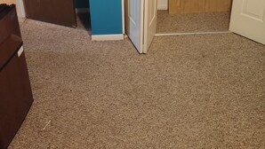 Ein Zimmer mit einer braunen Tür, einer blauen Wand und einer weißen Tür mit Holzpaneel.