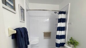Ein kleines Badezimmer mit Dusche, Toilette und Waschbecken.