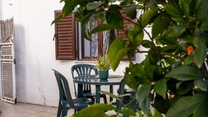 A patio with a table and chairs, a potted plant, and a window with shutters. - Cottage in the Guadiana valley, near Mértola (Portugal) (Mértola)